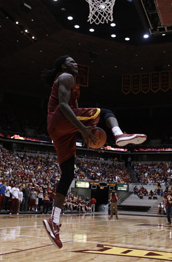 Redshirt junior forward Jameel McKay attempts a reverse between-the-legs dunk at the Hilton Madness dunk contest. The event, which took place in Hilton Coliseum on Oct. 18, filled the lower level with Cyclone basketball fans.