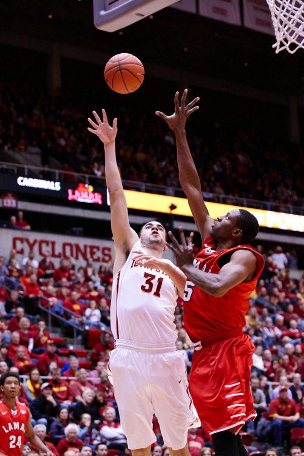 Junior forward Georges Niang shoots over Lamar senior forward Tyran de Lattibeaudiere at Hilton Coliseum. At the Dec. 2 game, Iowa State defeated Lamar 96-59 after a rocky start in the first half.