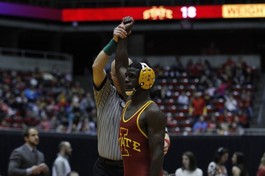 Junior Earl Hall defeats his Virginia Tech competitor and has his hand raised after the match. Iowa State defeated Virginia Tech 21-12 Jan. 18.  