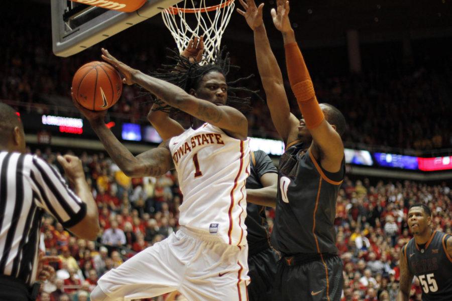 Redshirt junior forward Jameel McKay passes the ball under the net during Iowa States matchup with Texas on Jan. 26. McKay scored 14 points with one assist, helping the Cyclones to an 89-86 victory against the Longhorns.