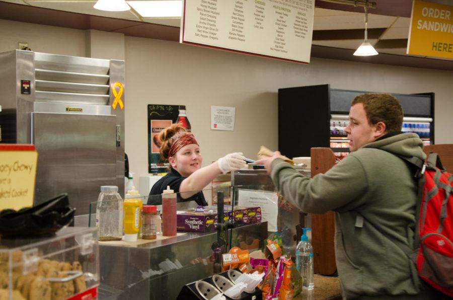 Meryl Onnen, a junior in public relations, serves food at West Side Market while at work Jan. 27, 2015.