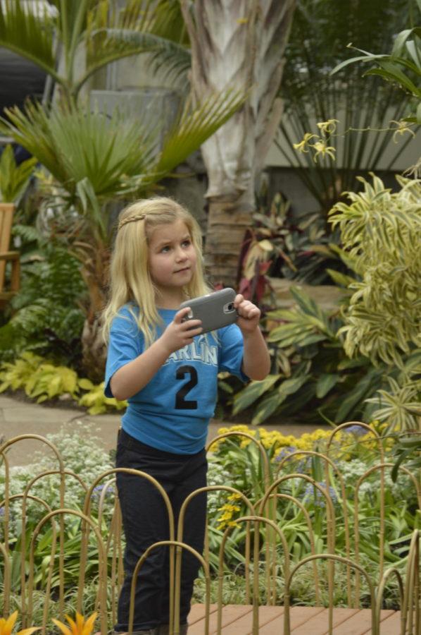 Sophia Moorman, a 6-year-old, takes a photo in the conservatory during Orchid Fest at Reiman Gardens on Feb. 8. The Orchid Extravaganza display marks the first time orchids have been displayed in the conservatory in 10 years.