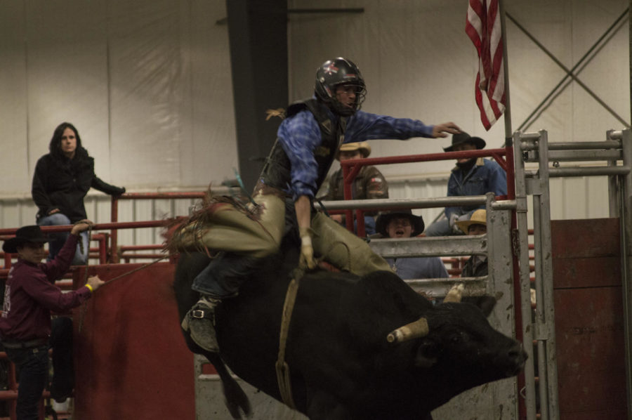 A rider is tossed around on a bull to begin the Double S Bull Company LLC indoor rodeo at Iowa State on Feb. 21.