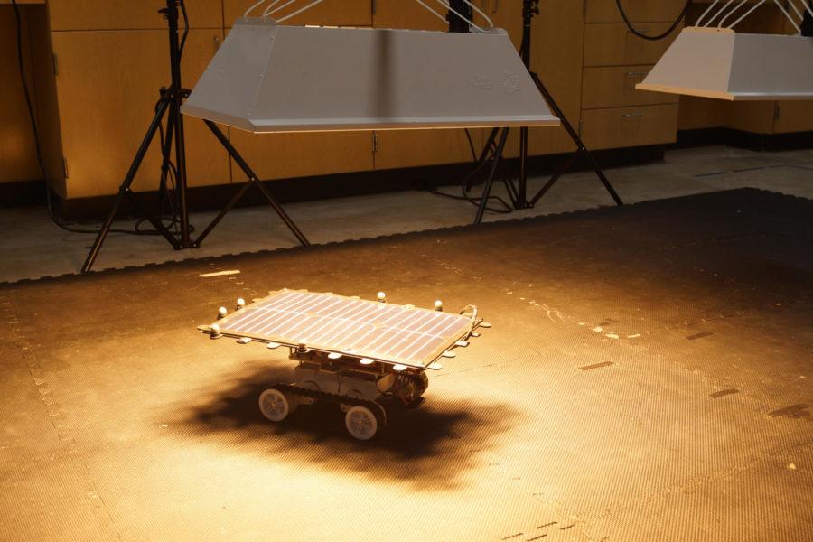 A solar-powered robot sits underneath a solar light lamp that was taken from the College of Agriculture.