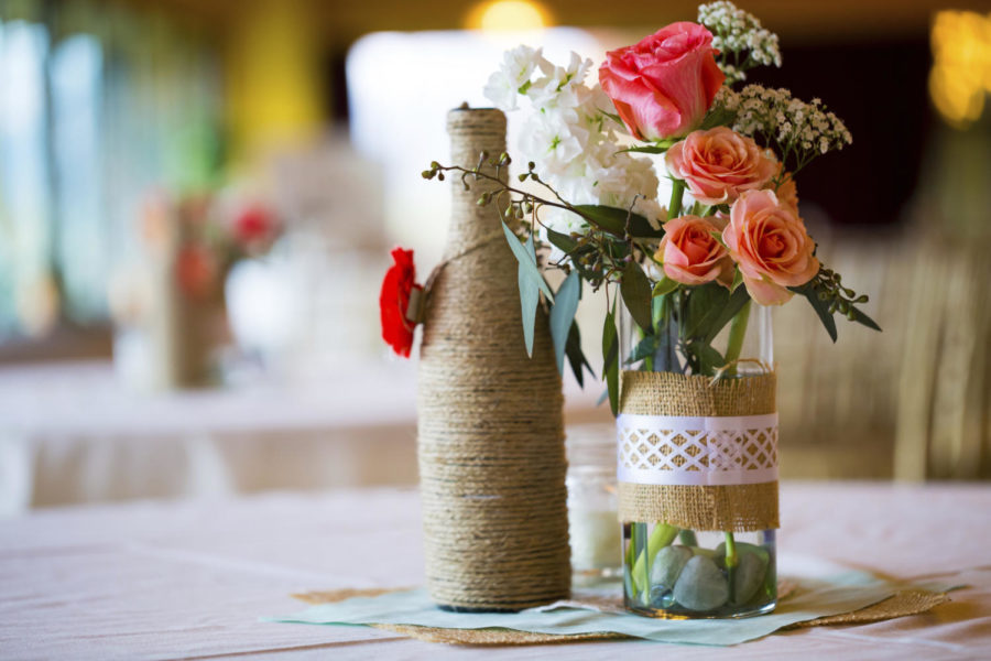 Mason jars provide an inexpensive options for table decorations, flower vases or drinking glasses at weddings. Other affordable decorations include painting used glass beer or wine bottles, which can be used as centerpieces or table number identifiers. 