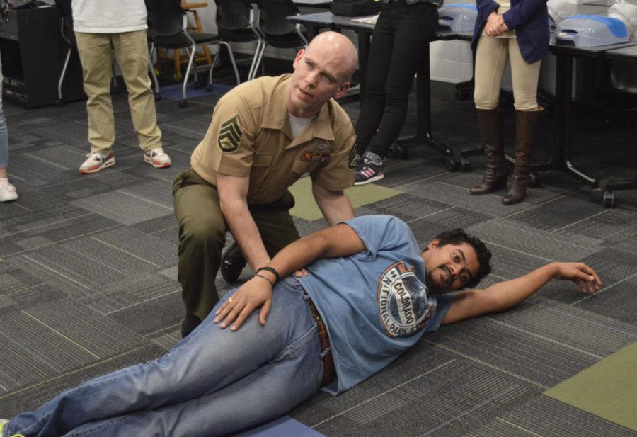 Staff Sgt. Chris Harrison used Sunny Mahajan, graduate student in civil engineering, to demonstrate the proper way to treat a victim who may have an air blockage. U.S. Education Without Borders and Naval ROTC sponsored the first aid and leadership training session for international students Tuesday afternoon in the Armory.