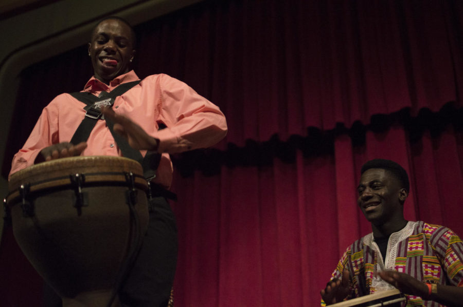 The host of the African Night event joins two other performers in performing a traditional drumming act on Saturday.