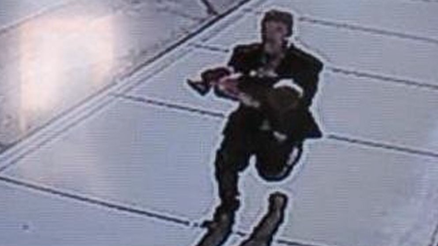 In this still image taken from surveillance video on Sunday, provided by the Lincoln County Sheriffs Office, a man runs down a street, carrying a toddler in an apparent kidnapping attempt in Sprague, Wash. (AP photo/LCSO)