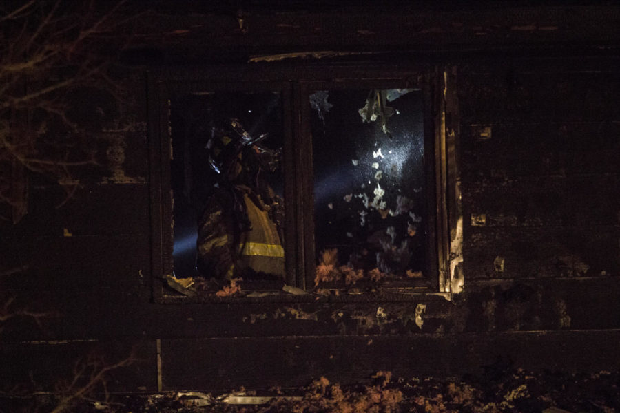 An Ames Fire Department firefighter surveys the insulation on the second floor of a home after a fire broke out late Sunday night at 1322 Illinois Ave. in west Ames. The Ames Fire Department and Ames Police Department responded to the fire. The cause of the fire was not immediately known. Neighbors said two of the three roommates got out of the house, but it was unclear if the third roommate was home or not.