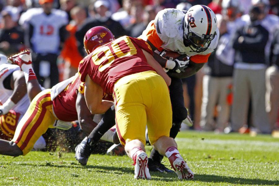 Redshirt freshman defensive end Mitchell Meyers tackles OSU running back Desmond Roland during Iowa States 58-27 lose to Oklahoma State at Jack Trice Stadium on Oct. 26, 2013. Roland had 219 yards on 26 carries.