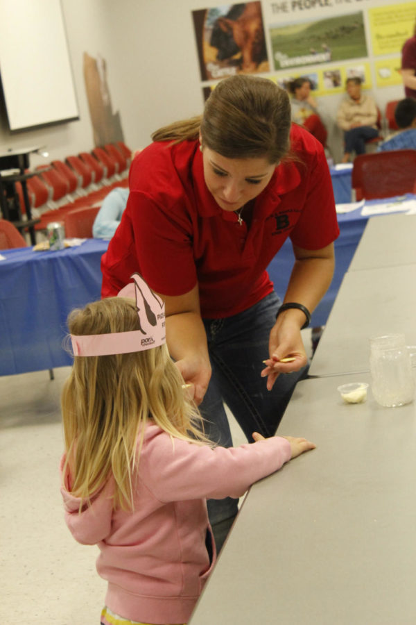The Jeff and Deb Hansen Agricultural Student Learning Center hosted Animal Science Day on April 11. There were food samples available, activities for children and farm animals to pet and learn about. Jenna Lansing, junior in agricultural business, helps children create their own butter. 