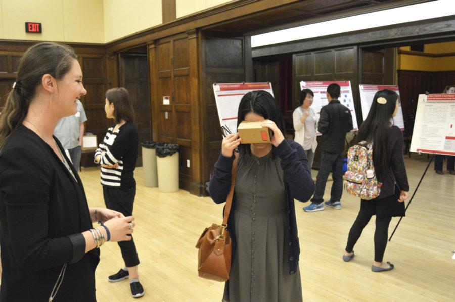 Chen Zhang, graduate student in graphic design, tries out Google Cardboard at Laura Huisignas poster booth Thursday afternoon at the GPSS Research Conference in the South Ballroom. Google Cardboard allows users to turn their smartphone into a virtual reality machine. Huisingas research focuses on how virtual reality can be used in the classroom.