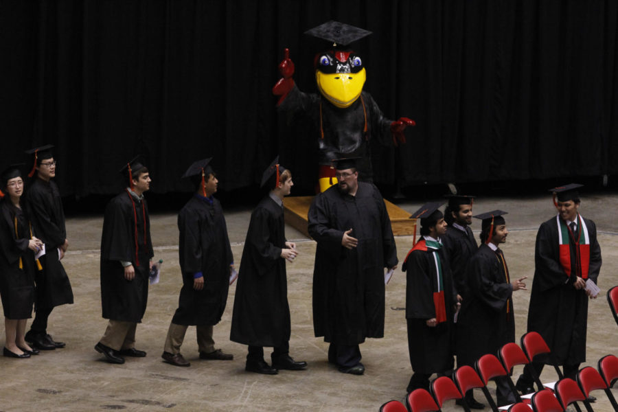 Graduates talk as they walk to their seats before the start of the undergraduate commencement ceremony Saturday at Hilton Coliseum. 