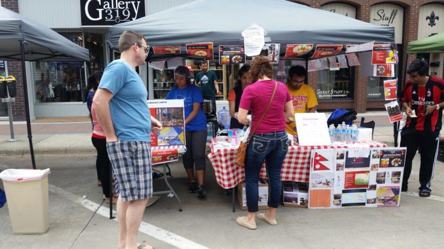 Members of the Nepal Student Association sell foodstuffs at the Ames Main Street Farmers Market on Saturday, May 16 to raise funds for earthquake victims in Nepal.