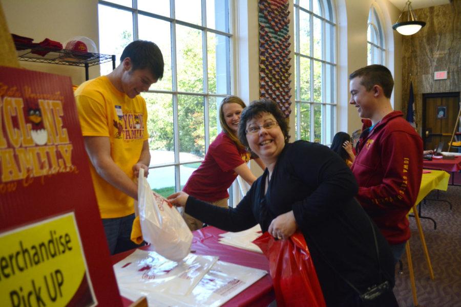 An ISU parent excitedly poses for the camera as she reaches out for her Cyclone Family Weekend merchandise.