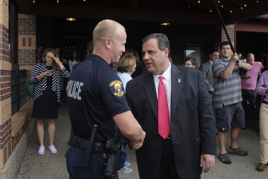 Chris Christie talks with a police office outside Hickory Park on Thursday, June 11.