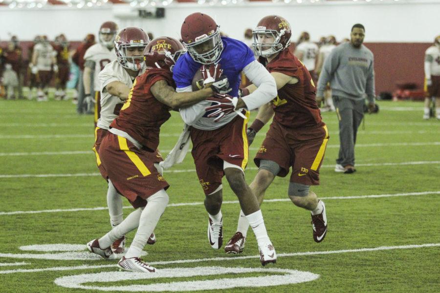 Redshirt senior Quenton Bundrage pushes through a tackle at the first football practice March 3 at Bergstrom Indoor Football Facility. Bundrage was limited in spring drills after tearing his against North Dakota State on Aug. 30, 2014. 
