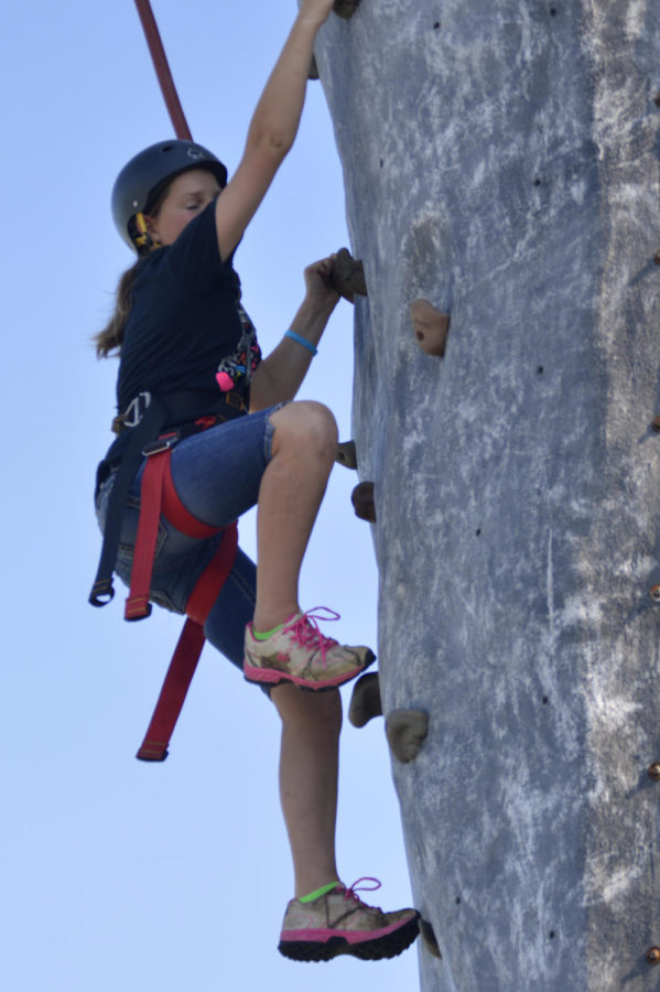 Mikayla Kloth climbs all the way to the top of a National Guard rock climbing wall. The wall was set up just outside of Jack Trice Stadium for the Iowa Games opening ceremonies on July 17, 2015. 