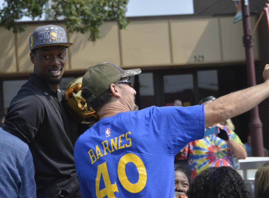 Grand Marshal Harrison Barnes takes time out for a photo with a fan before the start of the Ames 4th of July Parade on Saturday. Barnes led Ames High to consecutive state titles in basketball in 2009 and 2010. He now plays for the world champion Golden State Warriors.
