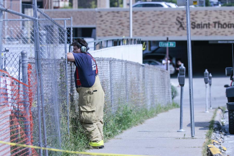 A member of the Ames Fire Department watches from outside of University Towers after a minor pool explosions halts construction.