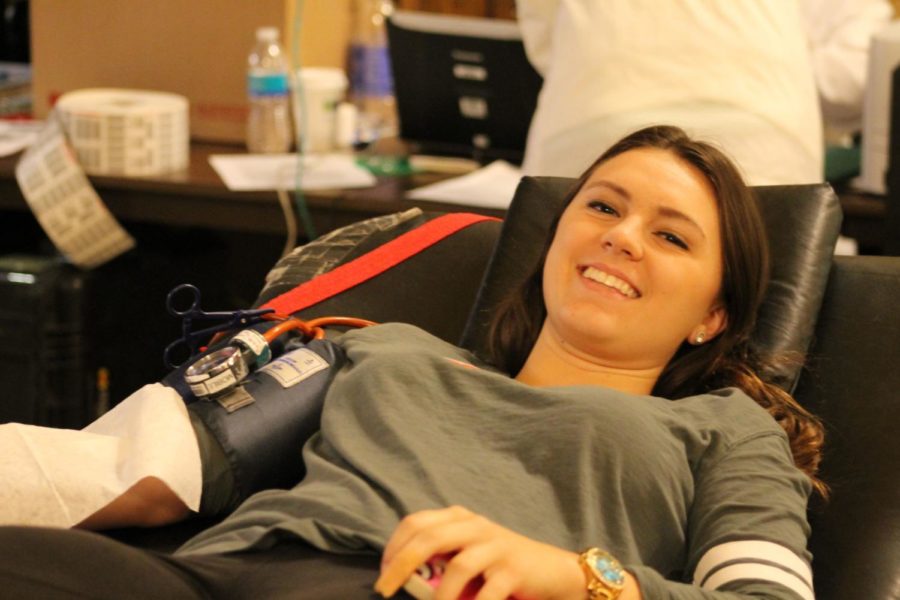 Alexis Romitti, freshman in apparel, merchandising and design, smiles while giving blood at the blood drive on Oct. 9. 