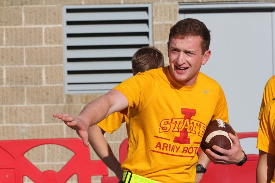 An Army ROTC cadet pretends to play football with the Cy-Hawk game ball after the Game Ball Run from Tama, Iowa.