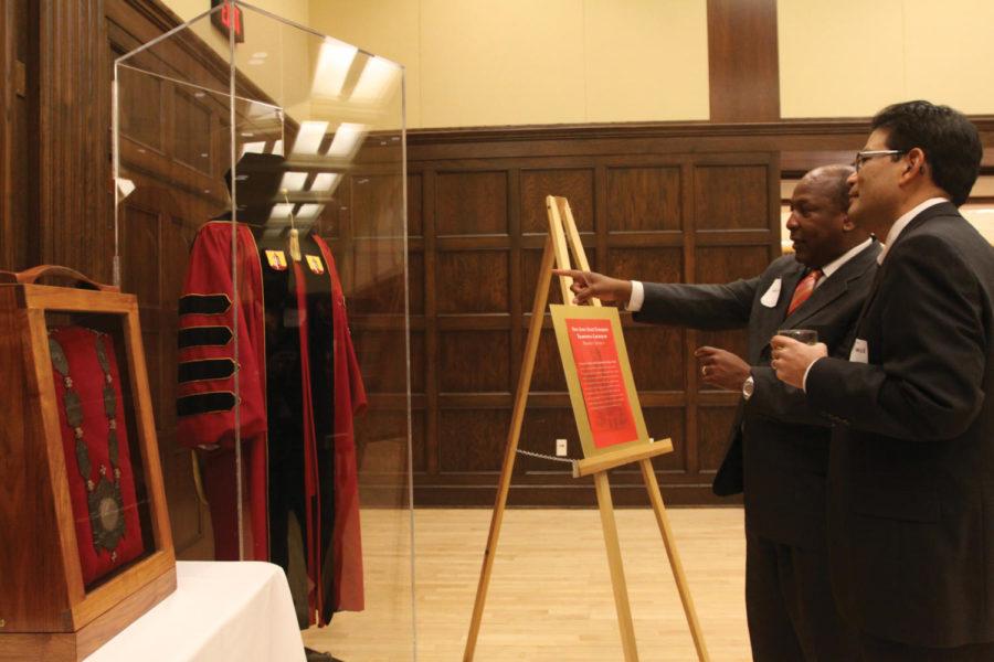 Jeff Johnson and Paul Tanaka stand in front of an exhibit
featuring ISU President Gregory Geoffroys graduation gown during
his farewell reception Thursday, Dec. 8, in the Sun Room of the
Memorial Union. Geoffroy is stepping down as ISU president in
January.
