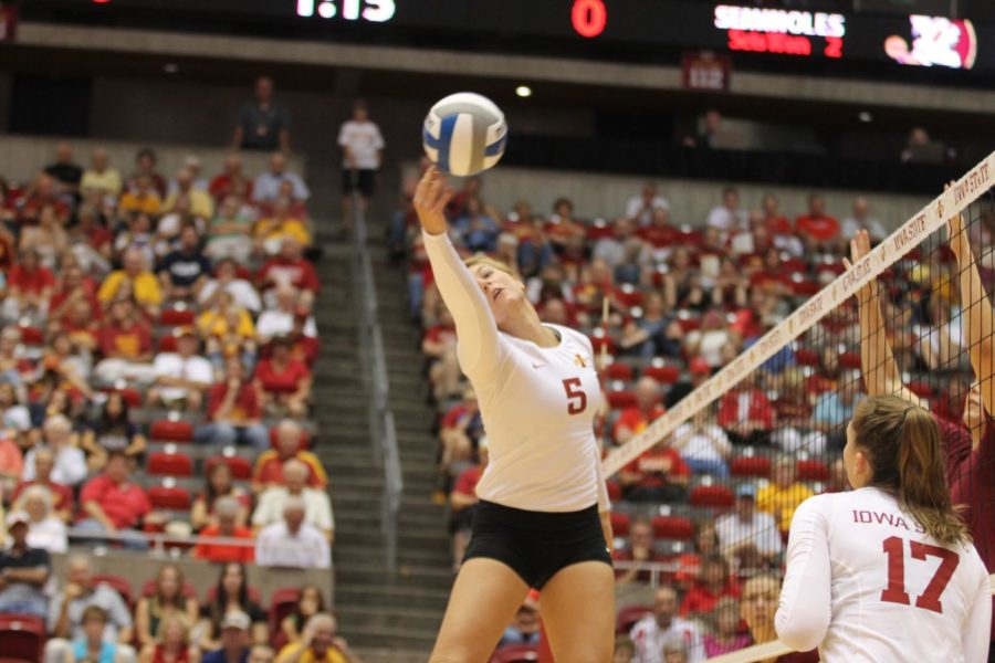 Middle blocker Natalie Vondrak tips the ball over the Florida State blockers to try and earn a point. Vondrak had one kill during the match on Aug. 31. 
