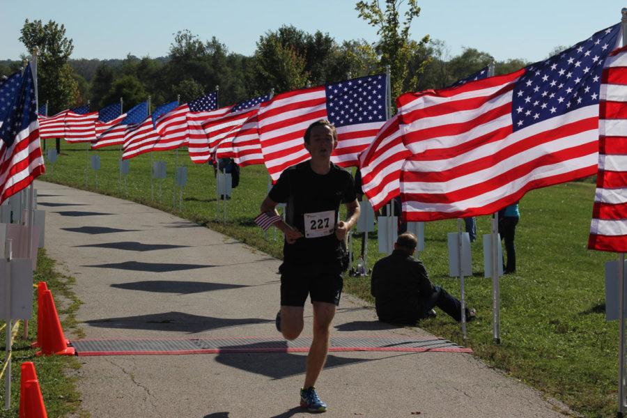 A participant in the Navy Remembrance Run finishes in the Raccoon River Park, West Des Moines, Sunday morning. The 5k run was to memorialize veterans who were lost at war.
