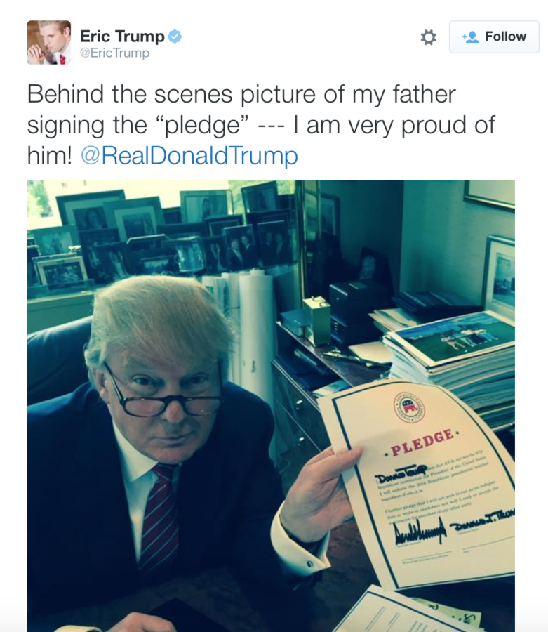 Donald Trump, Republican candidate for president, holds up a picture of a loyalty pledge he signed in a tweet from his son, Eric.