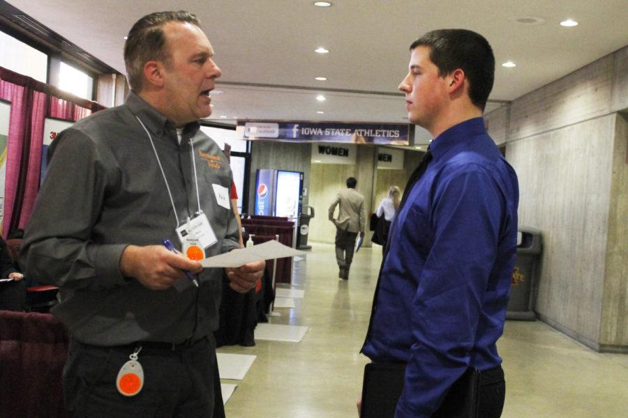 Ean Craft, junior in pre-business, speaks to a representative from Rembrandt Foods during the Career Fair at Hilton Coliseum on Feb. 11. 
