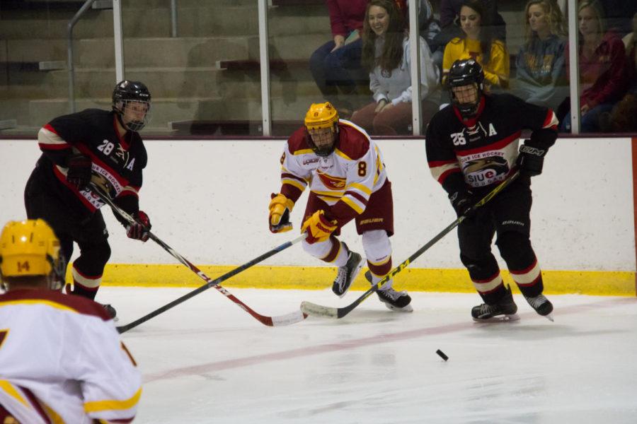 Freshman+Zack+Johnson+spots+the+puck+between+two+defensemen+during+a+game+against+the+Southern+Illinois-Edwardsville+Cougars+on+Sep.+19.+The+Cyclones+would+go+on+to+win+11-1.