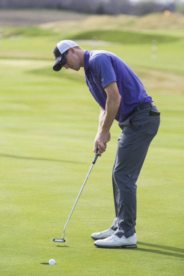 Collin Foster lines up a putt at practice on April 14, 2015. Foster, a redshirt senior, is Iowa States low-scorer through two rounds at the Bridgestone Golf Collegiate with scores of 75 and 70 to place in a tie for 30th.