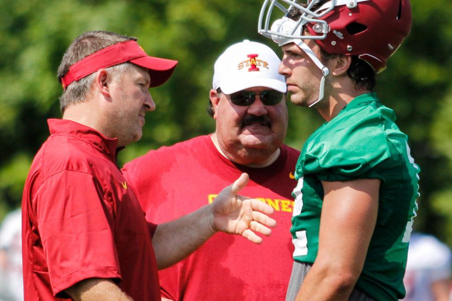 Coaches+Todd+Sturdy+and+Mark+Mangino+talk+with+redshirt+junior+quarterback+Sam+Richardson+at+the+first+fall+practice+Aug.+4.