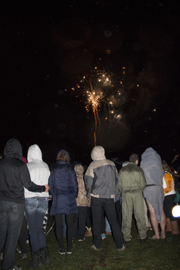 Students watch the fireworks on Central Campus Fri. night during mass campaniling. Legend has it that one does not become a true Iowa Stater until they're kissed under the campanile at midnight.