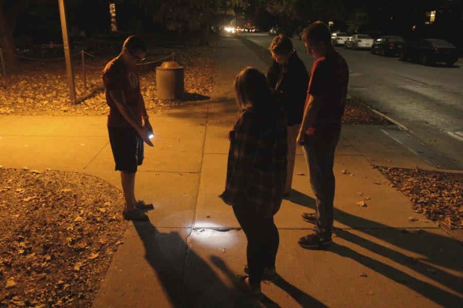 University Affairs Committee conducts a campus safety walk Monday. One of the group writes down the cracks on the sidewalk. 