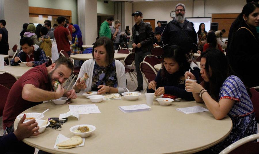 Sam Worley, Kat Lundberg, Hanan Mas'od and Zenia Adiwijaya enjoy their food at International Food Night 2015. This event was held on Nov. 10 at St. Thomas Aquinas Church from 7:00 to 9:30pm. Some of the groups offering food were the Association of Malaysian Students at Iowa State University and Vietnamese International Student Association.