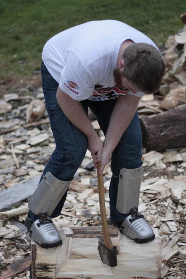 Forestry Club President Abraham Harms practices an underhand chop at the timbersports team practice area. The practice area is a part of the Forestry Club tree farm.