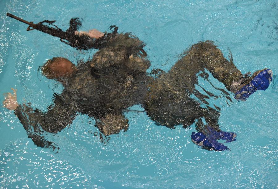 Matt Kelly, sophomore in chemistry, swims with a rubber rifle Wednesday November 18, 2015 during Army ROTCs Combat Water Swim Test in Beyer Hall at Iowa State. The CWST is designed to ensure that future Army officers are able to survive in the event that they find themselves in deep water while on a mission.