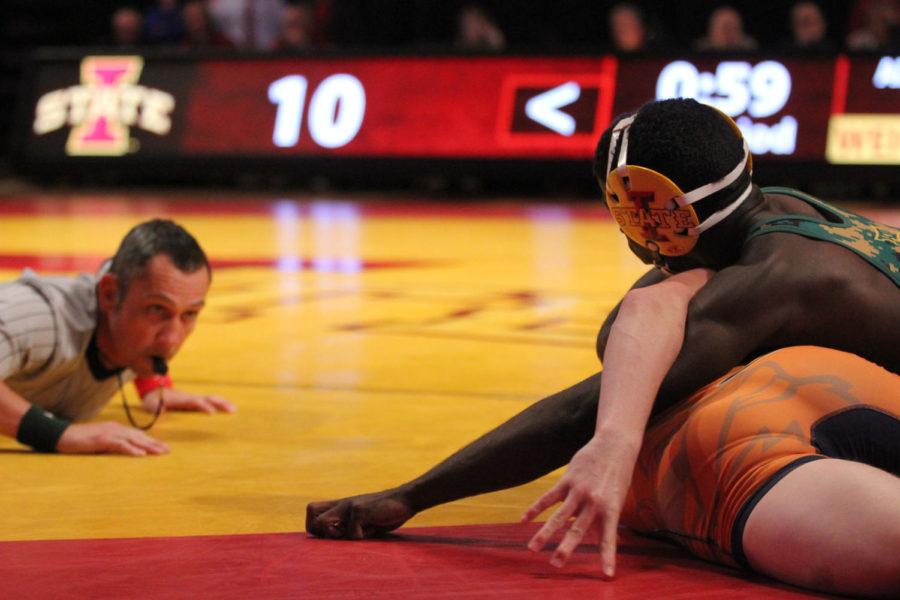 A referee watches as Earl Hall, senior, faces an opponent from Midland University on Nov. 12. Iowa State won 51-0.