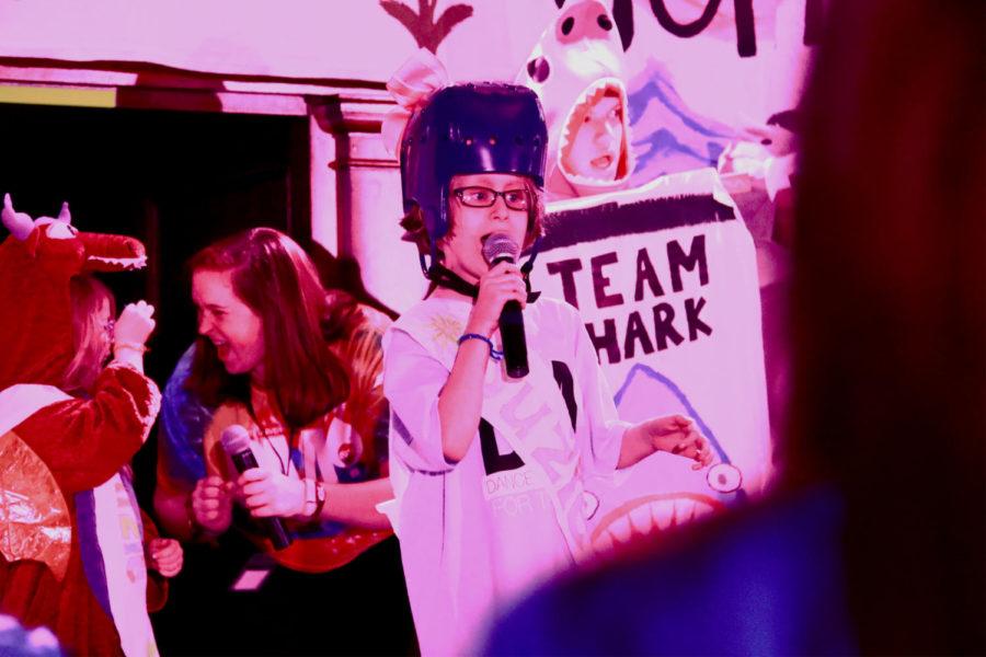 On Jan. 22, a Children's Miracle Network Hospital patient shows off her karaoke talent during the talent contest portion of the Iowa State Dance Marathon. In the background dance marathon team, "Team Shark" shows their support for the performance. 