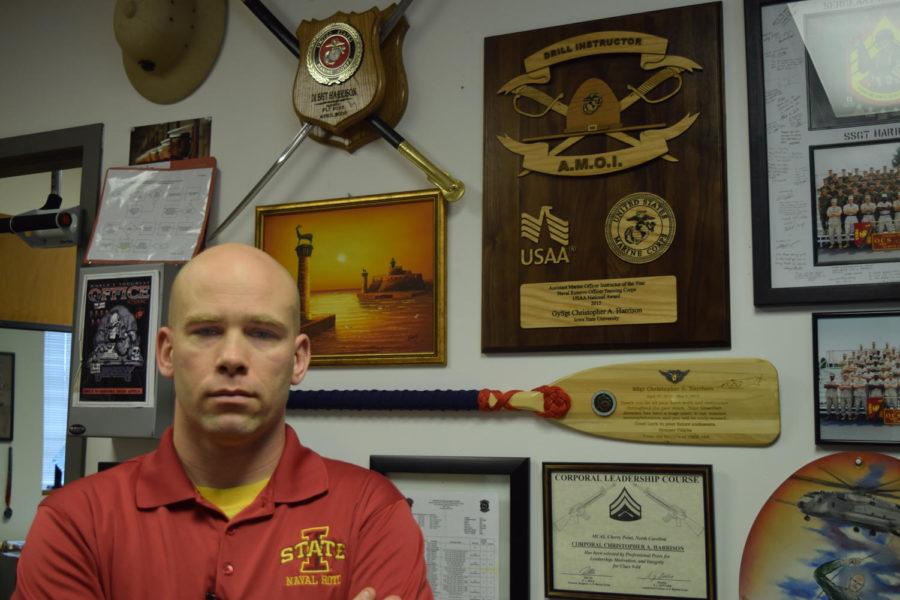 Gunnery Sgt. Christopher Harrison, assistant marine officer instructor, stands in front of the plaque that he won for being awarded the Assistant Marine Officer Instructor of the Year.