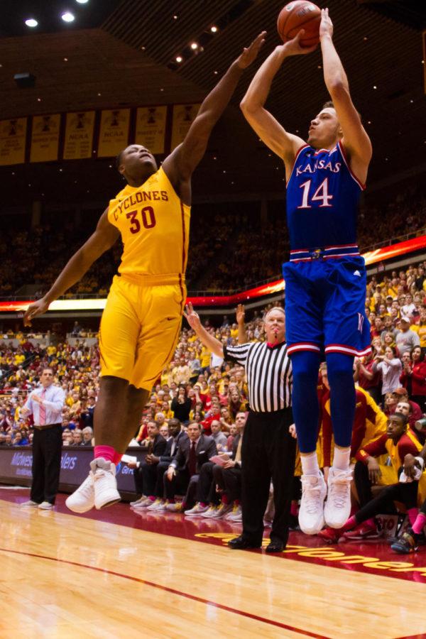 Kansas junior Brannen Greene takes a three point shot over ISU junior Deonte Burton during a game on Jan 25. The Cyclones would go on to win 85-72.  
