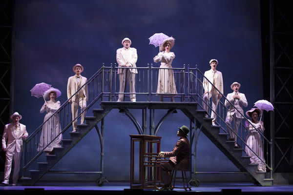 The white upper class stand above Coalhouse Walker, Jr. as Ragtime: The Musical begins.
