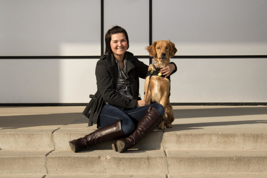 Cierra Featherstone, a junior in history, and her service dog Quinn sit on the steps outside Parks Library on Iowa State campus. Quinn is trained to be a mobility service dog. 