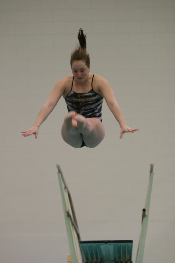 Elyse Brouillette, senior, performs a forward 2.5 somersault pike during the meet against the University of Illinois Fri. night. 