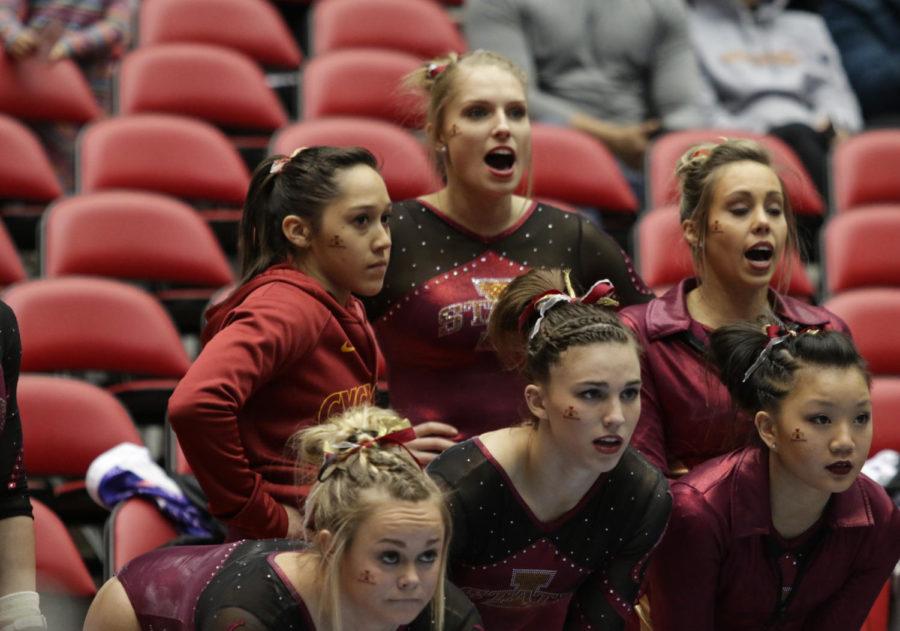 Members of the Iowa State gymnastics team watch teammate Kelsey Paz during her uneven bars routine Feb. 21. 