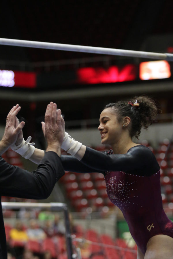 Sophomore Hilary Green high-fives head coach Jay Ronayne after her uneven bars routine during the meet against West Virginia on Feb. 5. Green scored a 9.05.