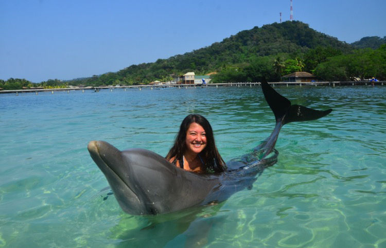 Cristina Cuhel, sophomore in animal science poses with a dolphin in the Roatan Island of Honduras during a spring break abroad program.