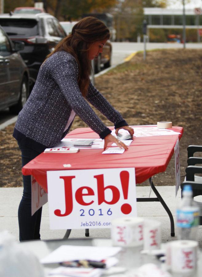 Kaylie Reicks, a junior in public service and administration in agriculture, sets up a booth outside the West Side Deli before the arrival of Jeb Bush Jr.